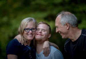 Family photo of two parents and a child with down syndrome